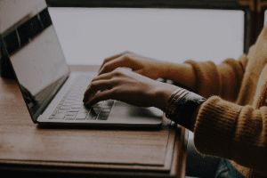 A person is typing on a laptop computer.