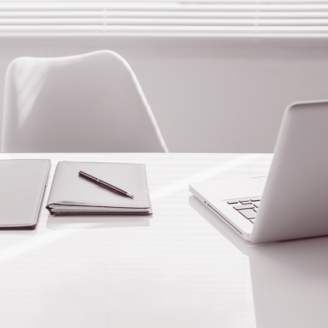 A cup of coffee is sitting next to a laptop computer on a table.