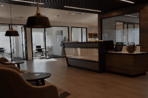 A large room with a reception desk and chairs in it