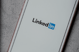 A close up of a cell phone with the linkedin logo on the screen.