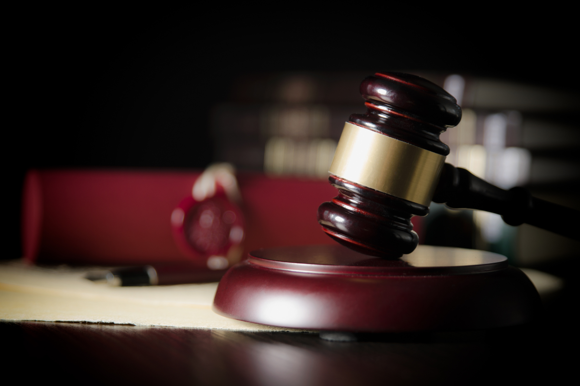 A wooden judge 's gavel is sitting on top of a wooden table.