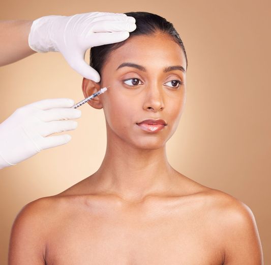 A woman getting a botox injection in her face.
