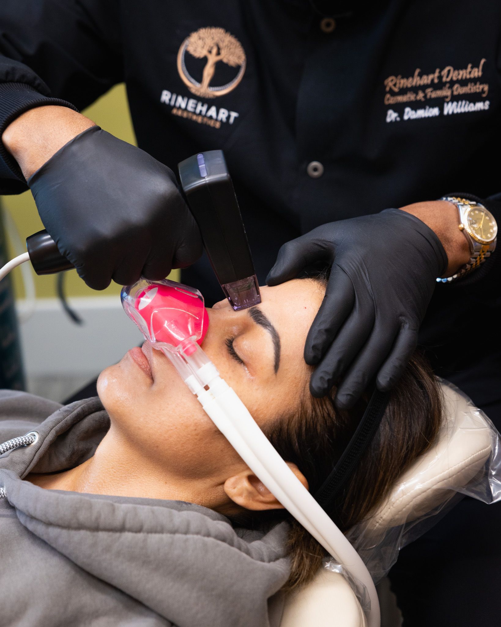 A woman is laying in a dental chair with an mask on her face receiving a Morpheus8 treatment.