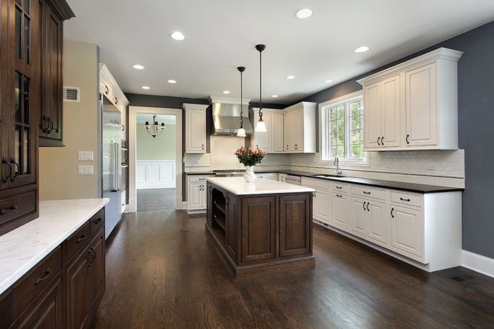 A kitchen with white cabinets and a large island in the middle.