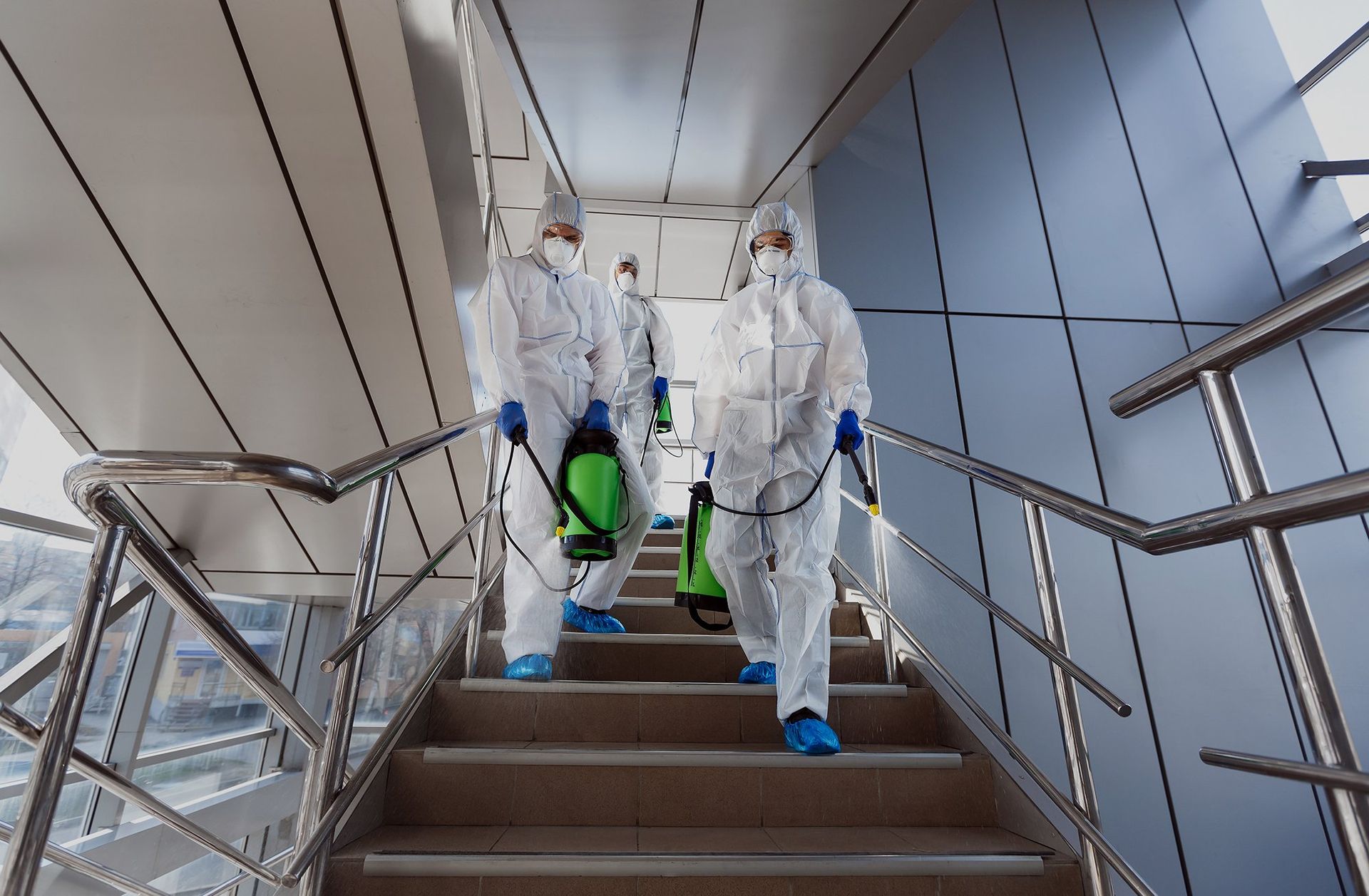 A group of people in protective suits are walking down stairs.
