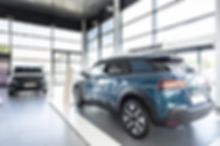 A blue car is parked in a car showroom.