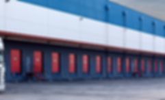 A blurry picture of a warehouse with a truck parked in front of it.