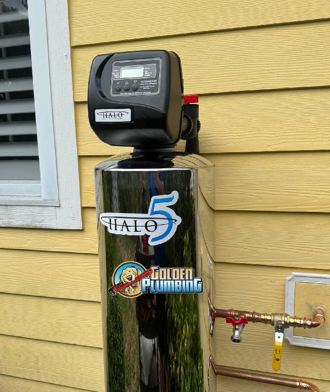 A water softener is sitting on the side of a house.