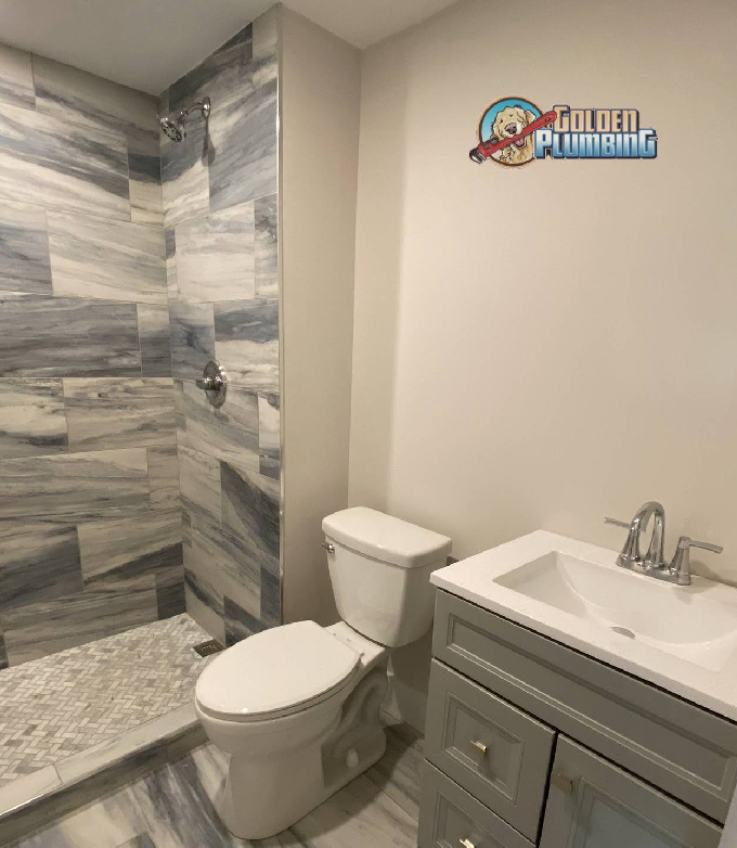 A bathroom with a toilet a sink and a sign that says golden plumbing