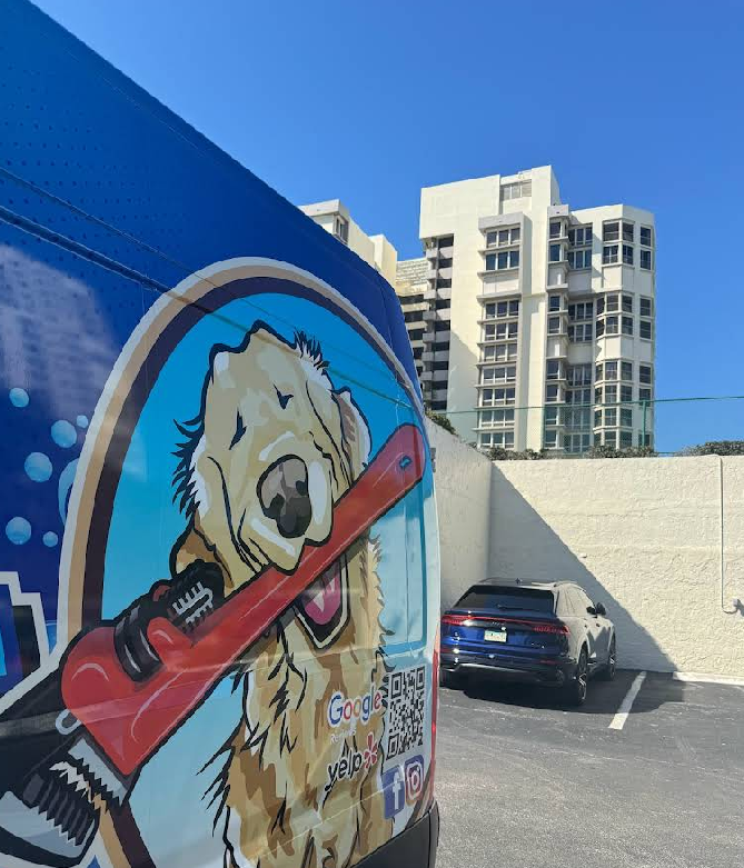 A blue van with a picture of a dog holding a wrench