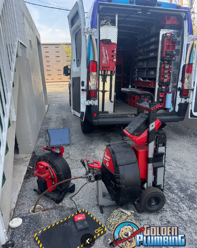 A plumber 's van is parked next to a drain cleaner.