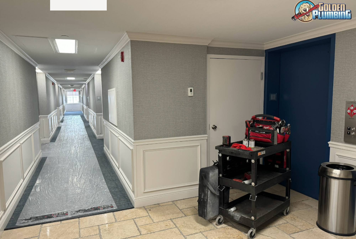 A long hallway with a cart and a trash can