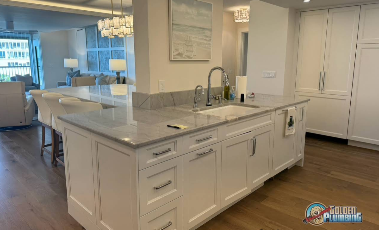 A kitchen with white cabinets , granite counter tops , and a large island.