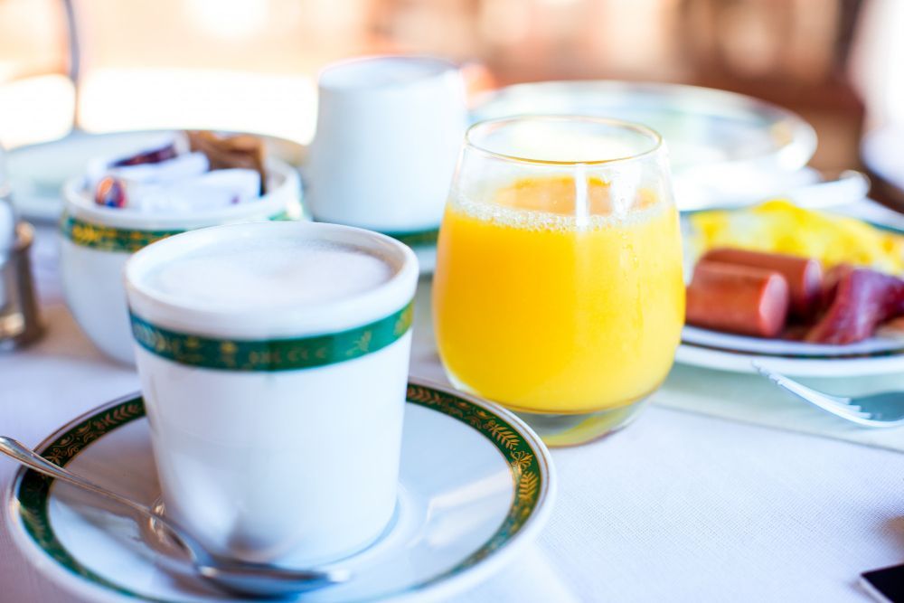 Há uma xícara de café e um copo de suco de laranja na mesa.-Hospedagem-Chamonville