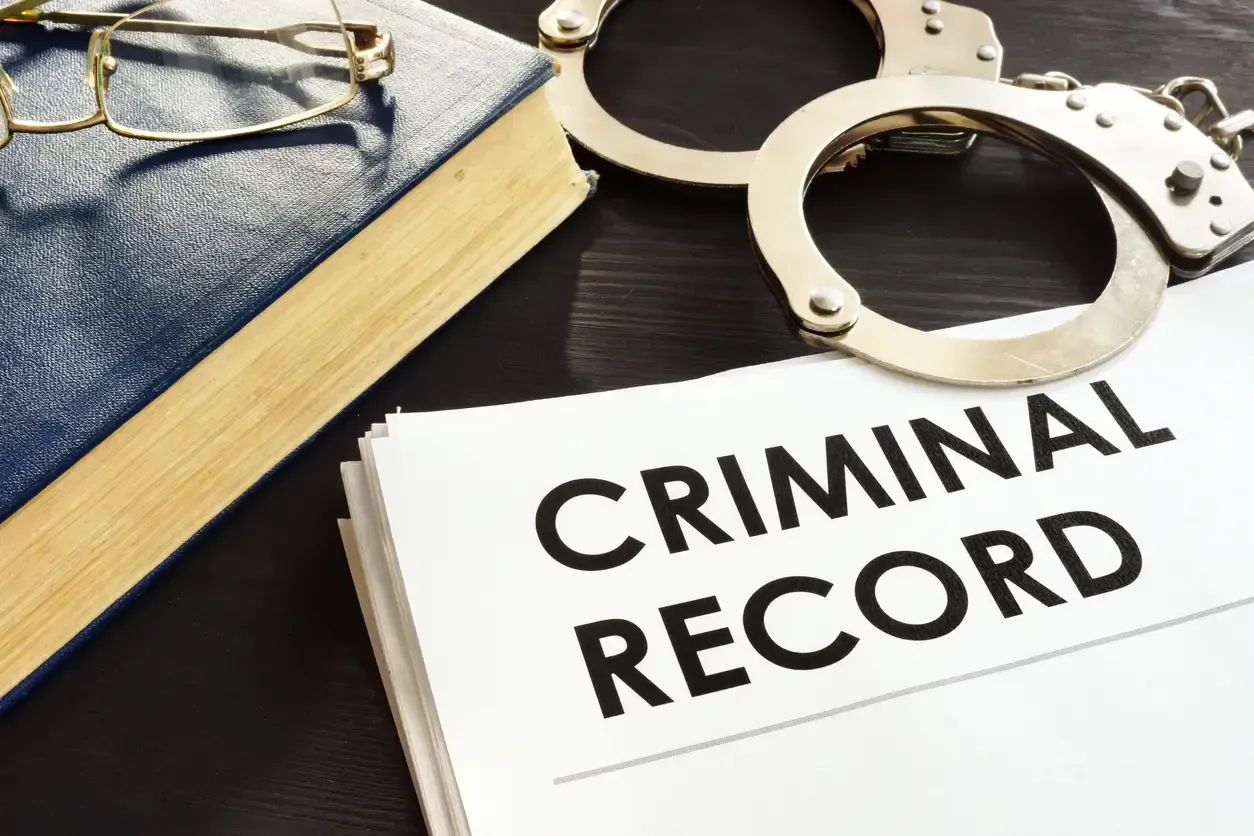 Criminal record and handcuffs on a desk representing criminal records in Canada