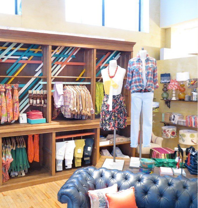 A living room with a couch and clothes on display