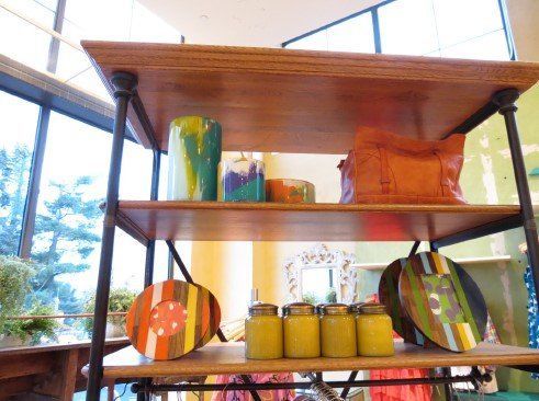 A wooden shelf with plates and jars on it