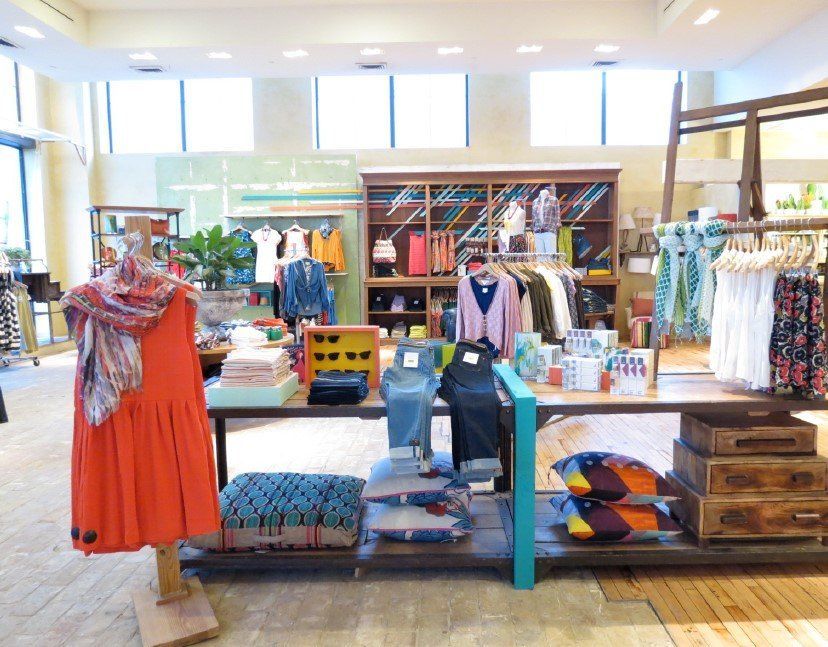 A store with clothes on display including an orange dress