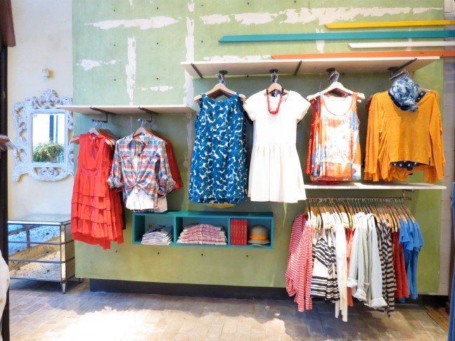 A row of clothes hanging on a wall in a store