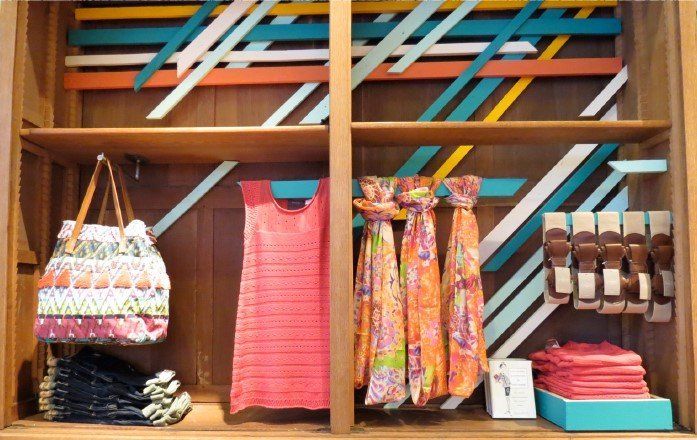 A display case with clothes and handbags on it