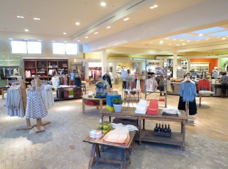 A kitchen with white cabinets , stainless steel appliances , and a large island.