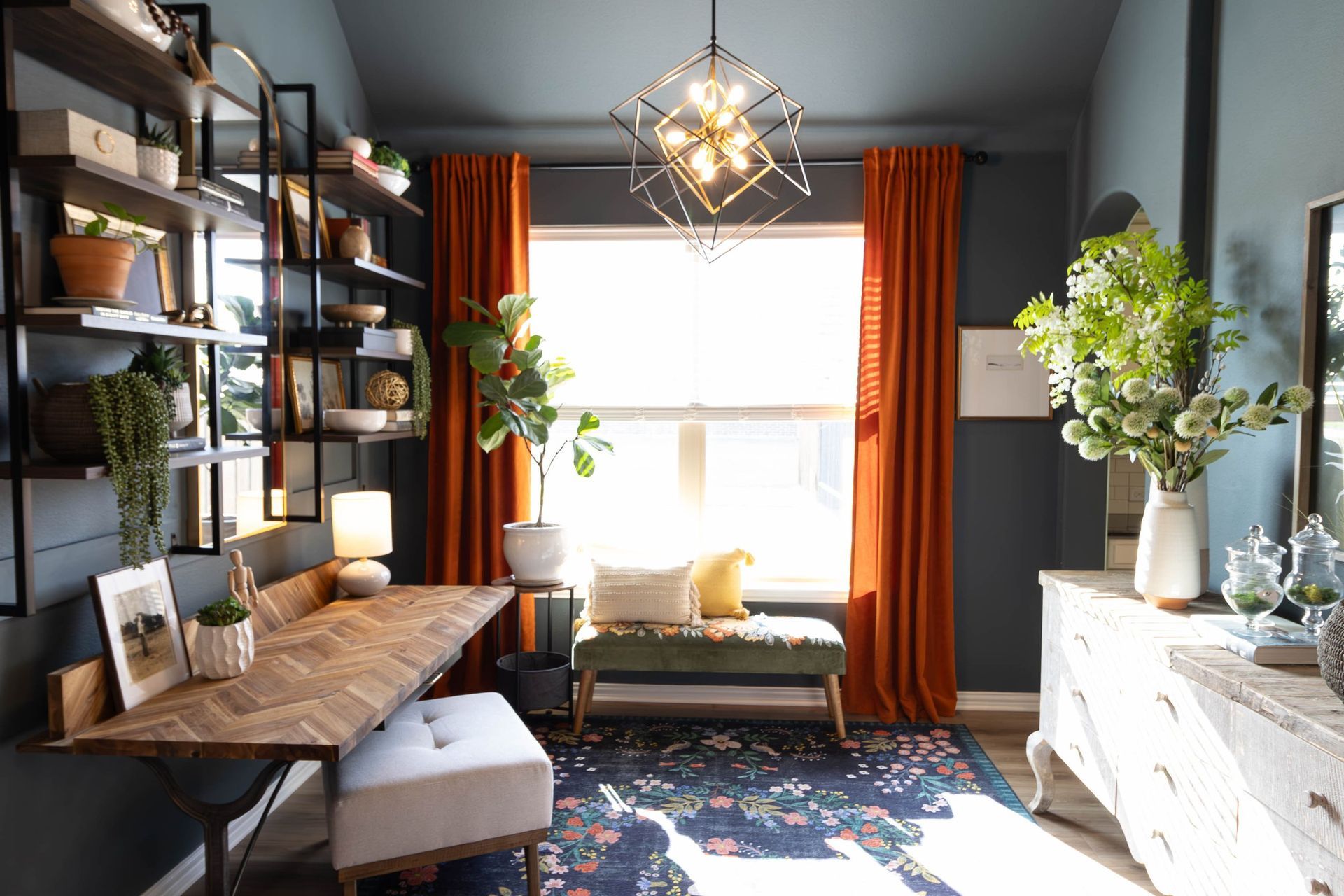 A home office with a desk , dresser , bench and window.