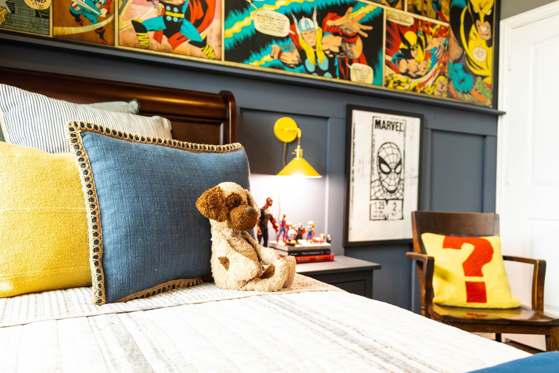 A teddy bear is sitting on a bed in a bedroom.