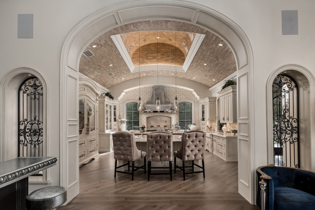 A kitchen and dining room in a house with a vaulted ceiling.