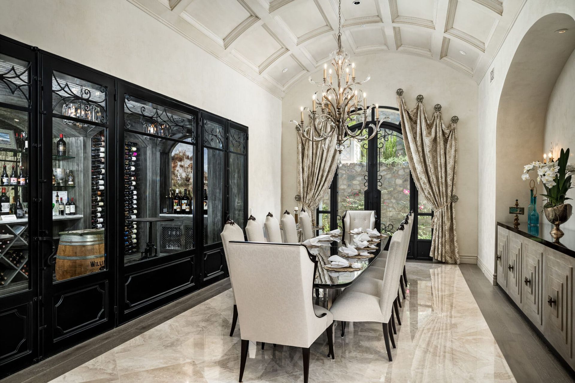 A dining room with a long table and chairs and a chandelier.