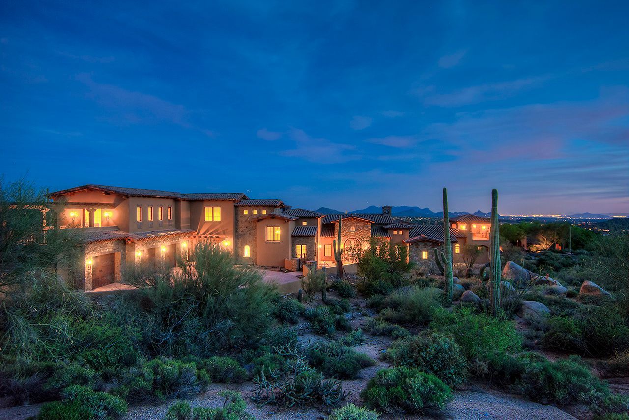 A large house in the middle of a desert at night.