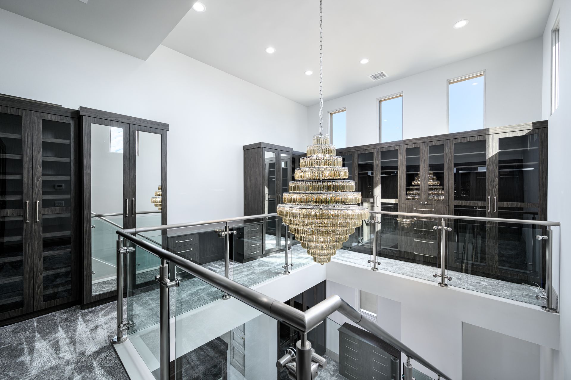 two story closet with chandelier and cabinetry