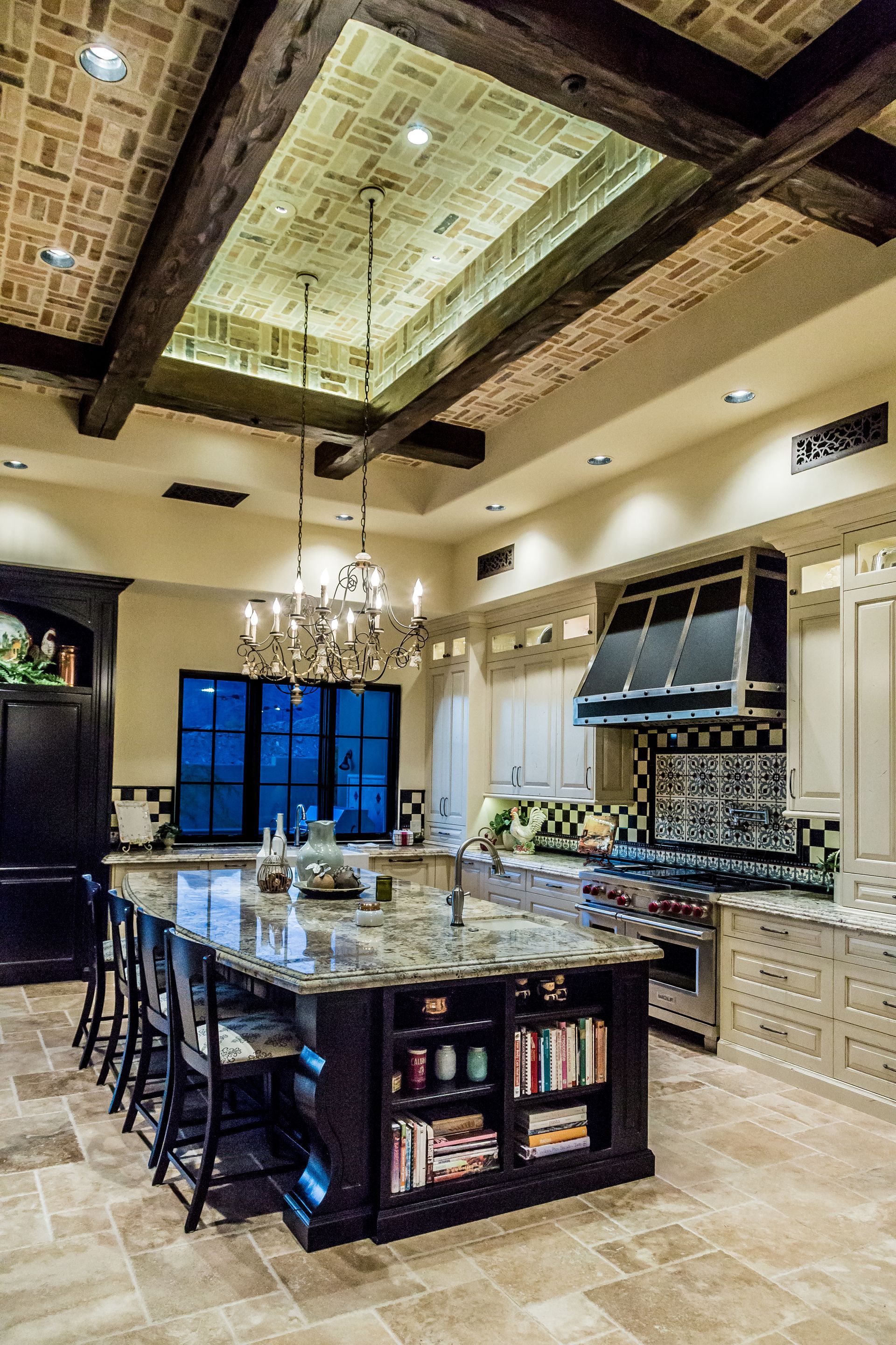 A kitchen with a large island and a chandelier hanging from the ceiling.