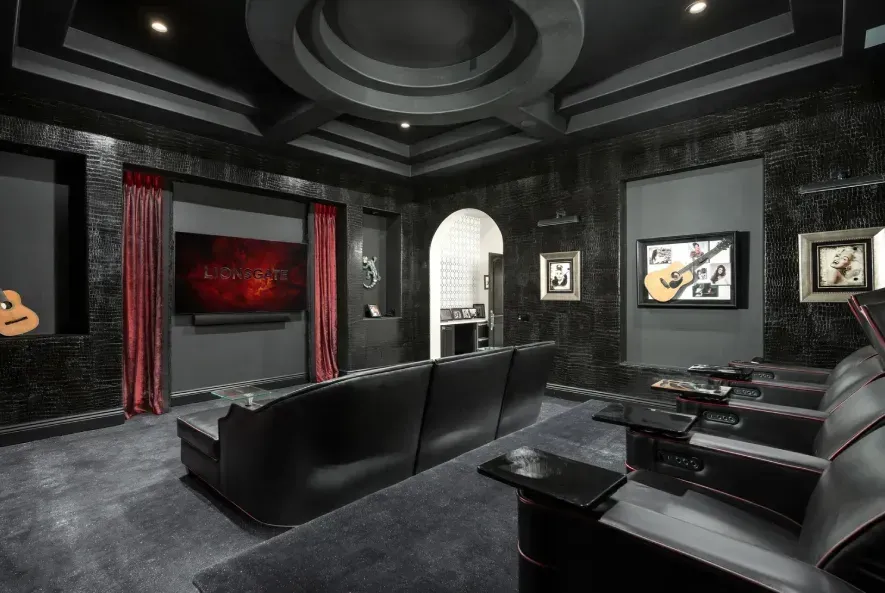 Luxury home theater with black walls and custom lighting