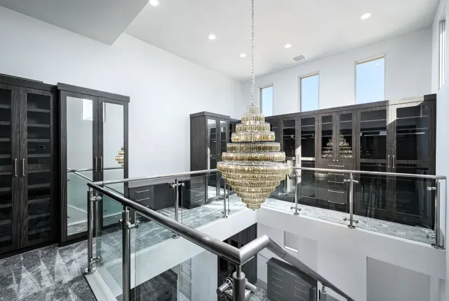 Walk-in closet with chandelier in luxury master suite