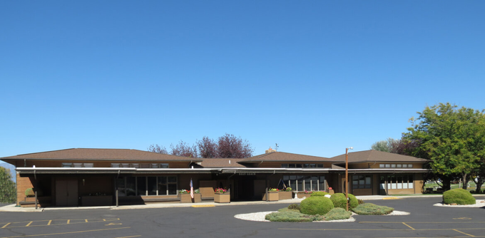 A large building with a parking lot in front of it.