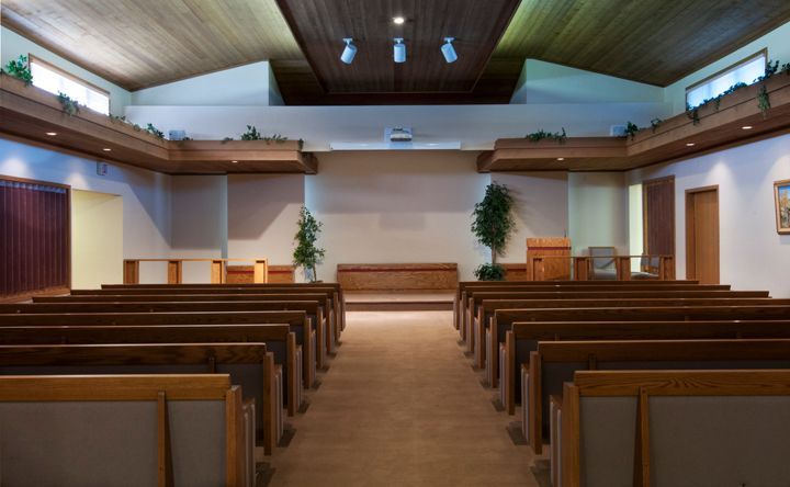 A man in a suit is carrying a coffin in a cemetery.