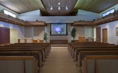 There is a projector screen in the middle of the church.