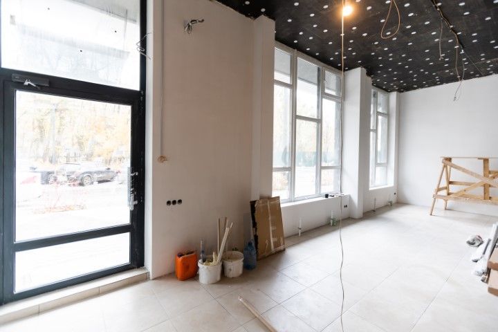An empty room with a lot of windows and a black ceiling.