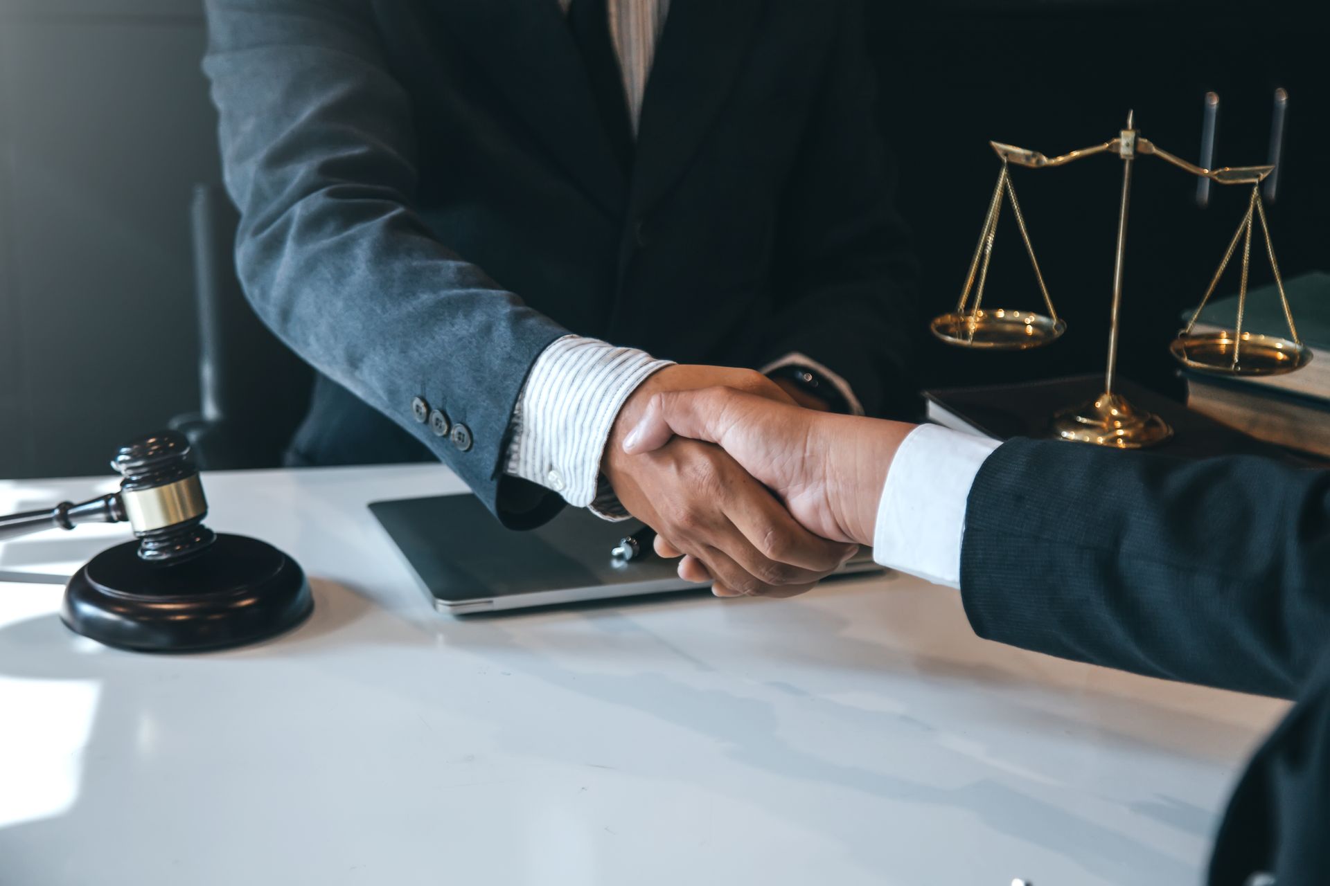 Two People in Suits Shaking Hands Near a Gavel — Dwyer Law Group in Surfers Paradise, QLD