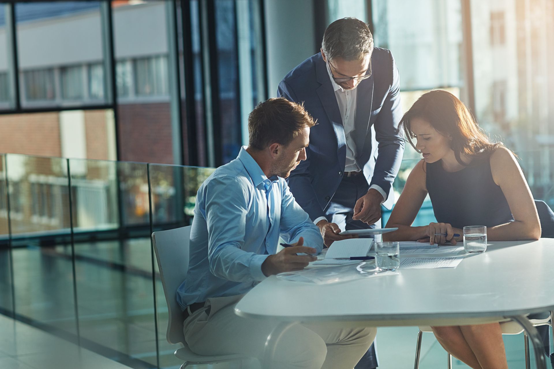 Three People Collaborating Around a Table in a Modern Office — Dwyer Law Group in Surfers Paradise, QLD