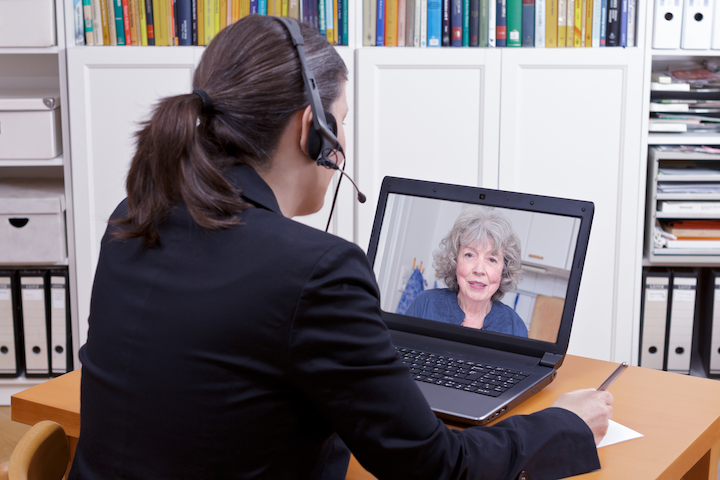 A lawyer in a remote consultation with an elderly client via laptop computer.