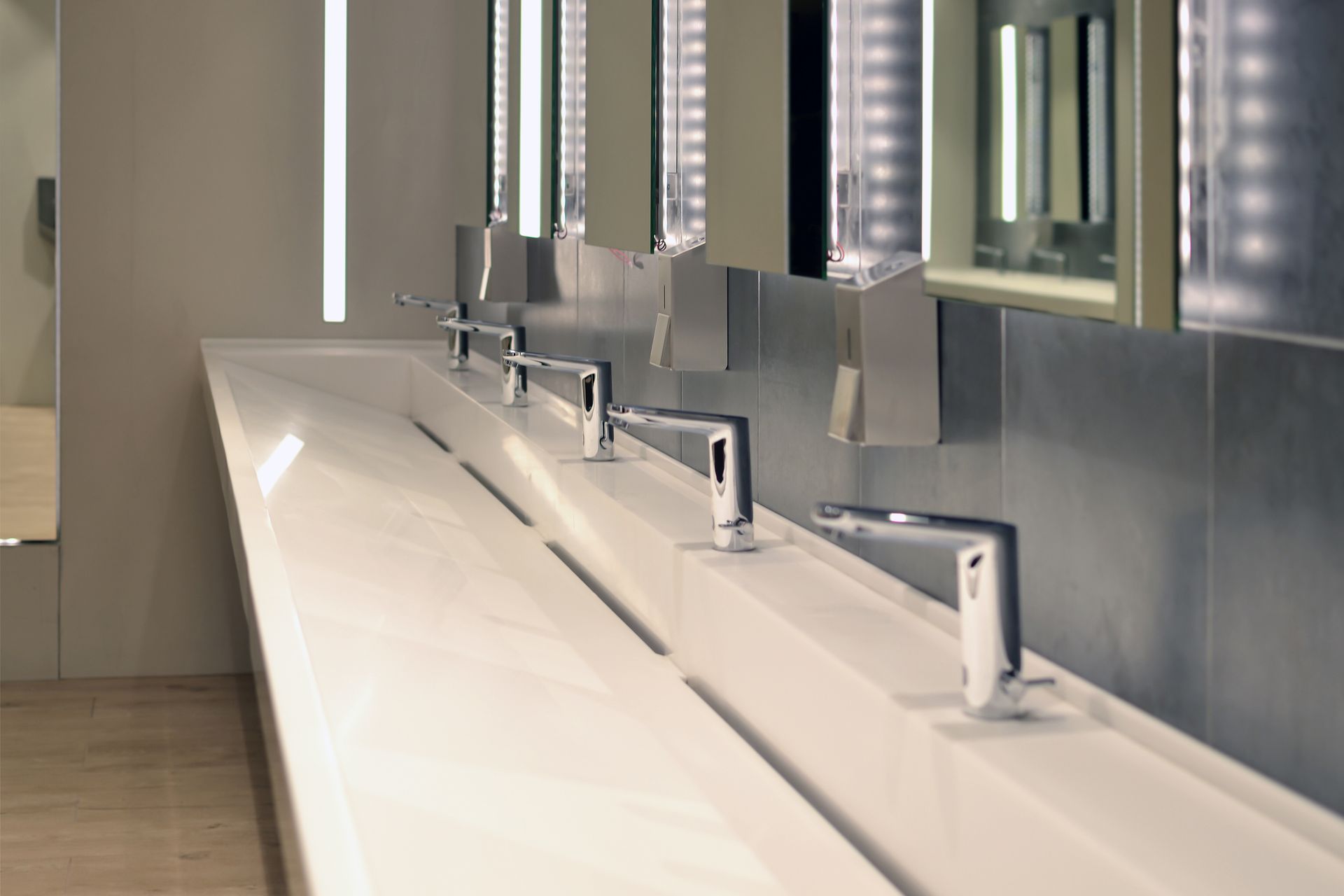 Commercial bathroom, sink and containers for antibacterial soap.