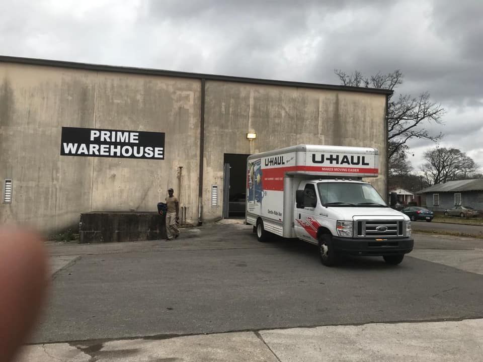 U-Haul truck parked in front of Prime Warehouse. A person stands near the entrance.
