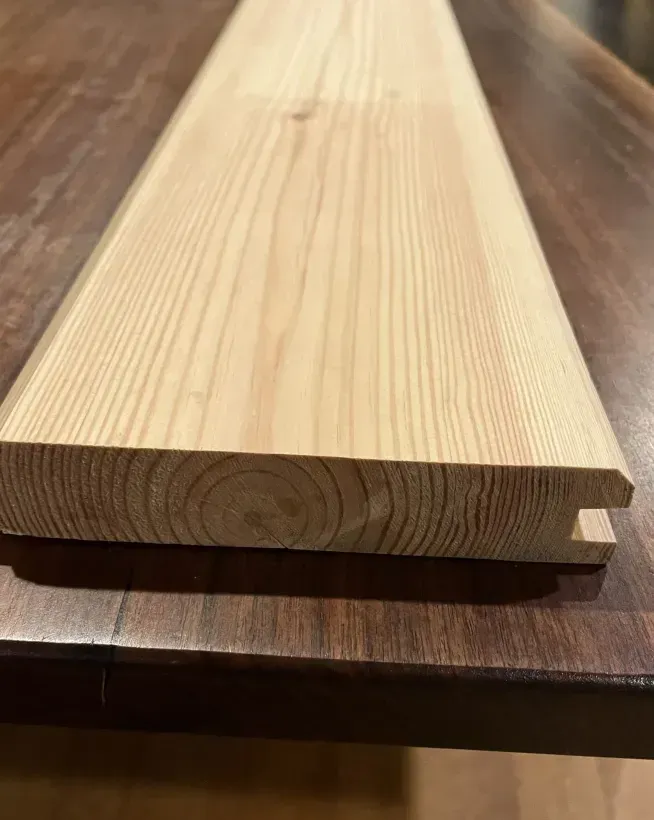 A piece of wood is sitting on top of a wooden table.
