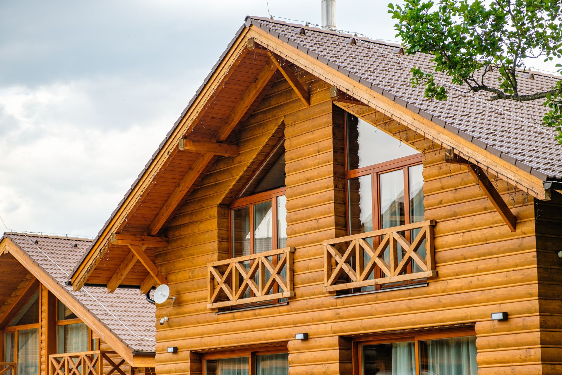 Wooden cabin with brown roof and windows; bright day.