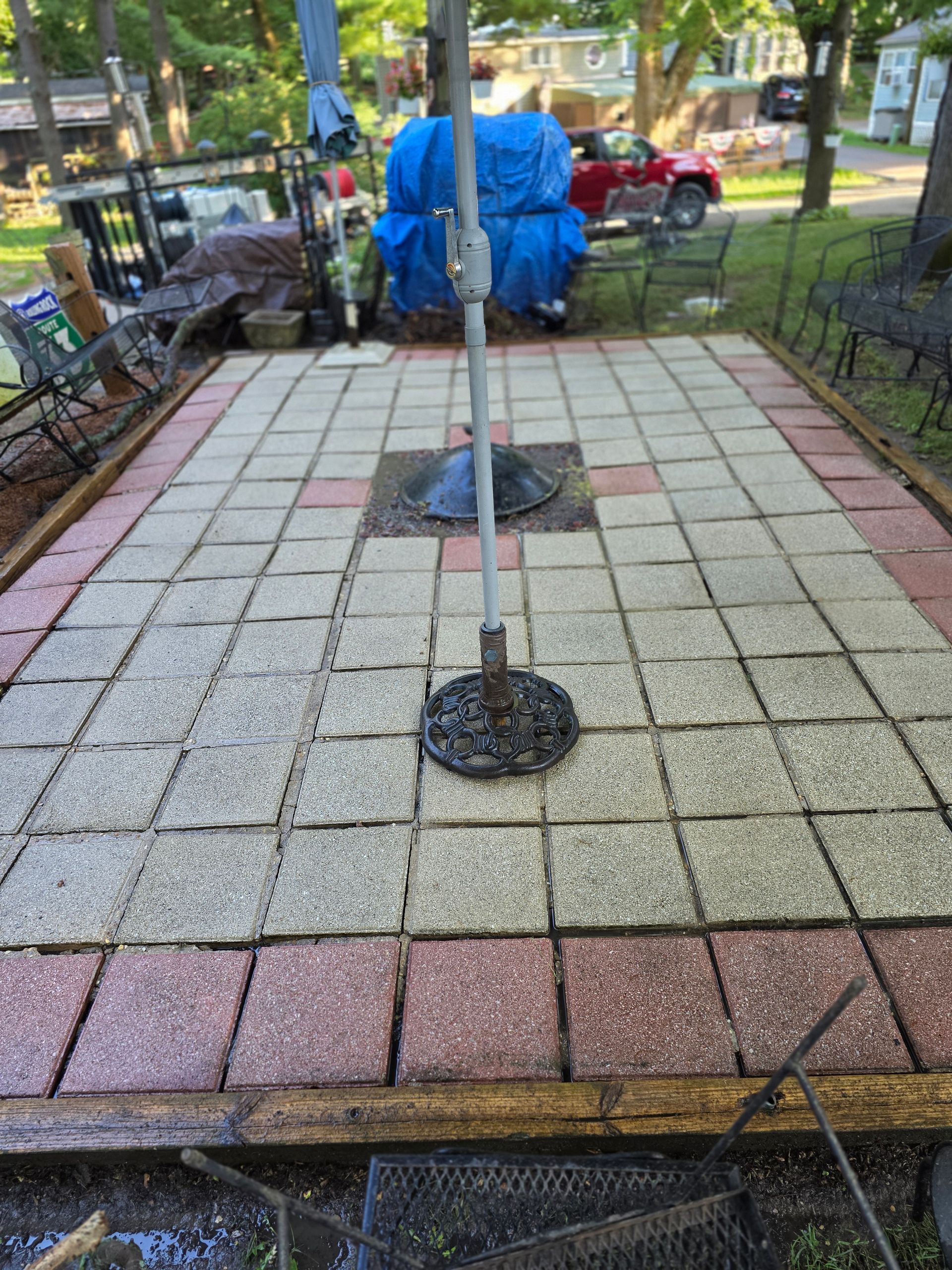 A yard with a retaining wall, cart, and a sign for