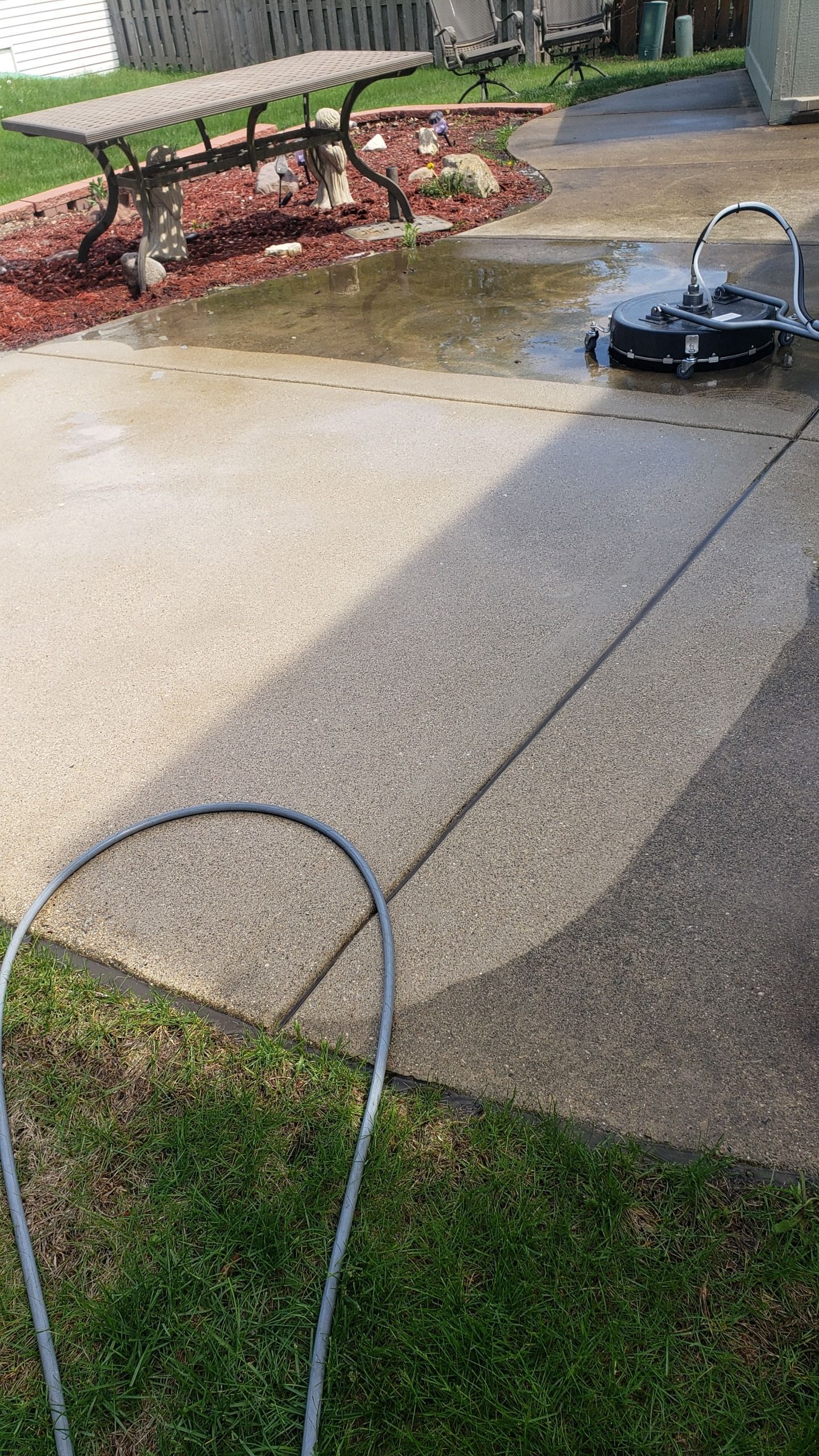 Pressure washer cleaning a concrete patio.