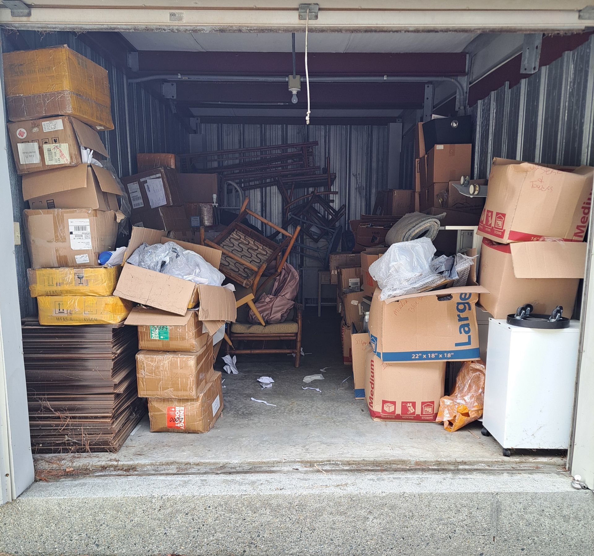 Storage unit filled with packed boxes and various items.