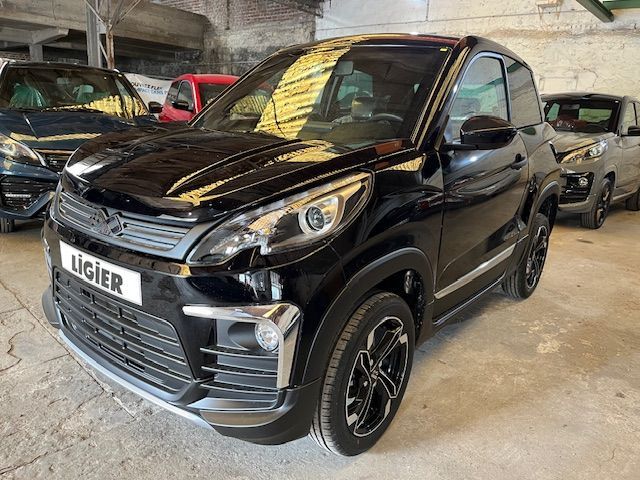 Une ligier noire est garée dans un garage à côté d'autres voitures.