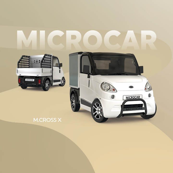 Une microcar blanche mcross x roule sur une route.